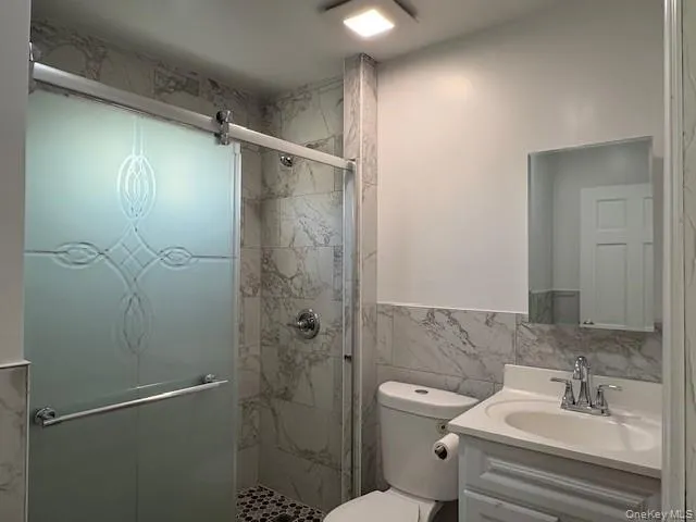 a bathroom with a shower a sink and toilet