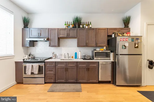 a kitchen with stainless steel appliances granite countertop a refrigerator a stove a sink and a refrigerator