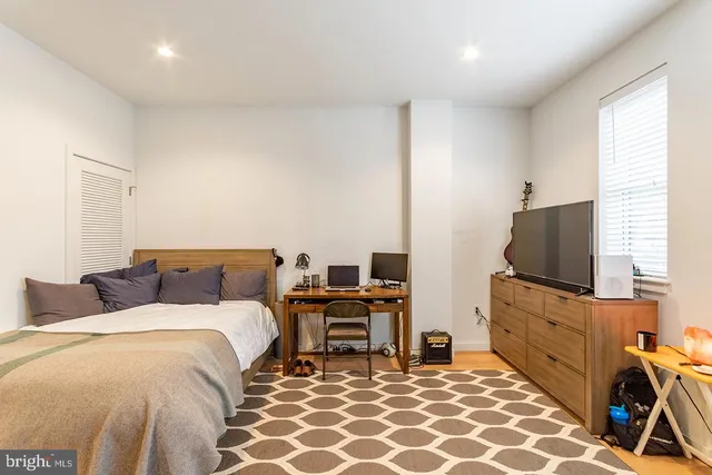 a bedroom with a bed and a flat screen tv