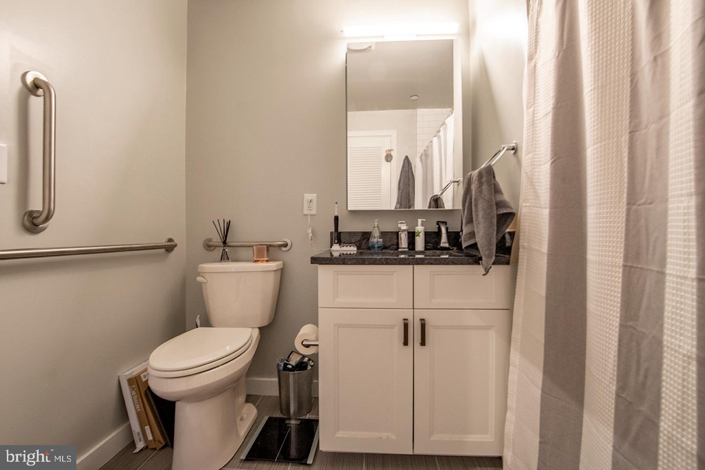 507 South 8th Street, Unit 103 Philadelphia, PA 19147 - Photo 5 of 7 a bathroom with a toilet a sink and a mirror