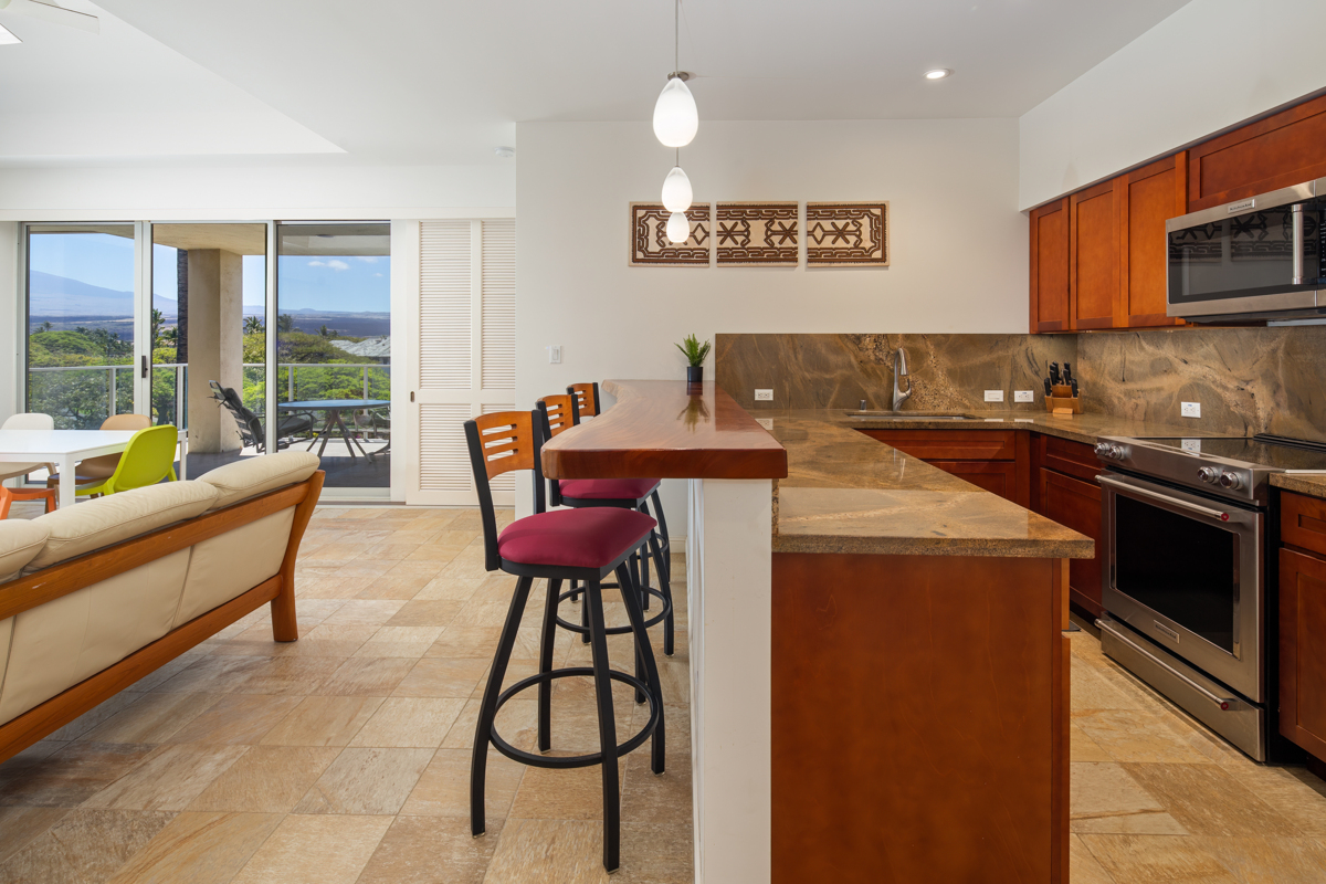 69-1010 Keana Place, Unit D304 Waikoloa, HI 96738 - Photo 1 of 30 a kitchen with stainless steel appliances kitchen island granite countertop a sink and a refrigerator