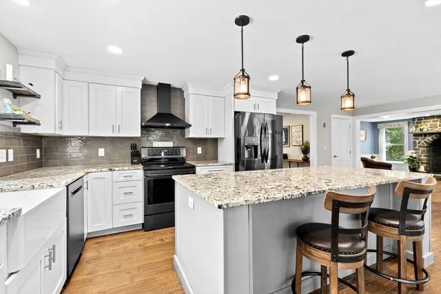 a kitchen with stainless steel appliances kitchen island granite countertop a stove a sink and chairs