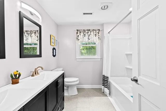 a spacious bathroom with a toilet sink and mirror