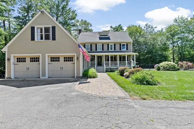 a front view of a house with a yard and potted plants