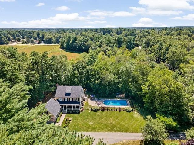 an aerial view of a house with a garden and lake view