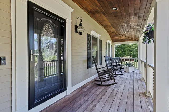 a view of a porch with furniture and wooden floor
