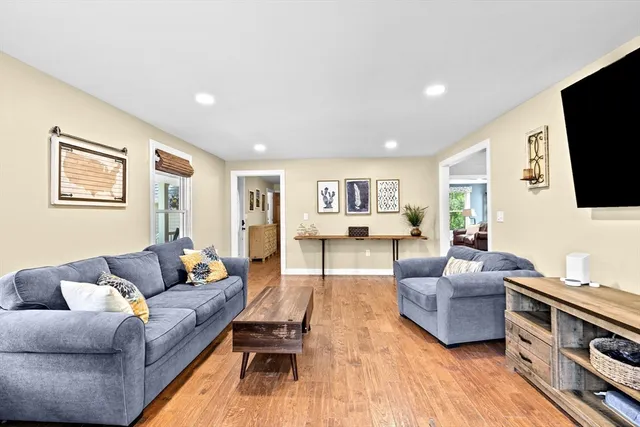 a living room with furniture flat screen tv and wooden floor