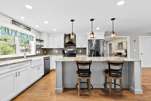 a kitchen with refrigerator and chairs
