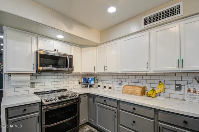 a kitchen with stainless steel appliances a stove a sink cabinets and a microwave