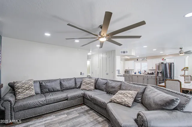 a living room with furniture and a ceiling fan