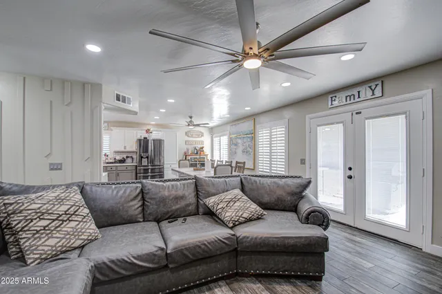 a living room with furniture and a ceiling fan