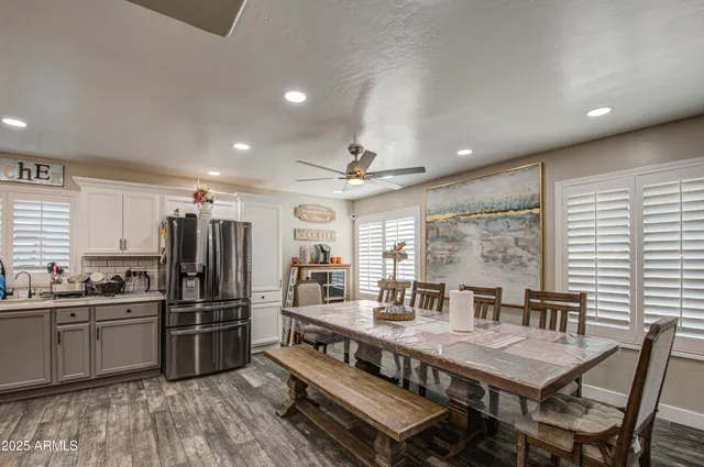 a kitchen with stainless steel appliances a kitchen island wooden floors and white cabinets