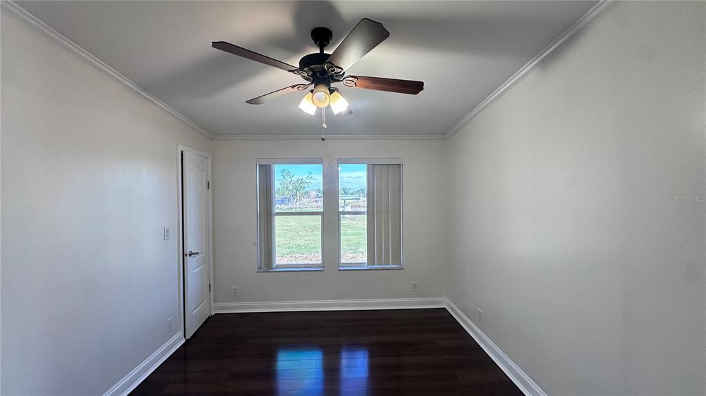35495 Singletary Road Myakka City, FL 34251 - Photo 66 of 74 an empty room with wooden floor fan and windows