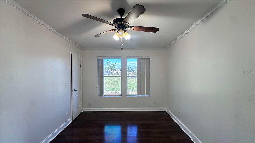 35495 Singletary Road Myakka City, FL 34251 - Photo 67 of 74 an empty room with wooden floor fan and windows
