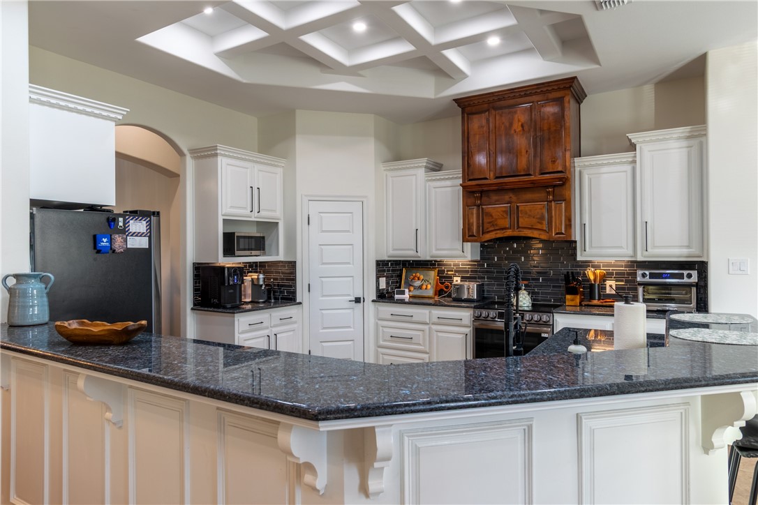 108 County Road 1601 Alice, TX 78332 - Photo 6 of 32 a kitchen with granite countertop a sink a counter space cabinets and stainless steel appliances