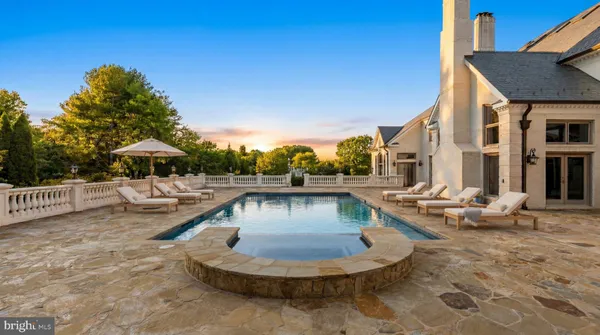 a view of a house with swimming pool and sitting area