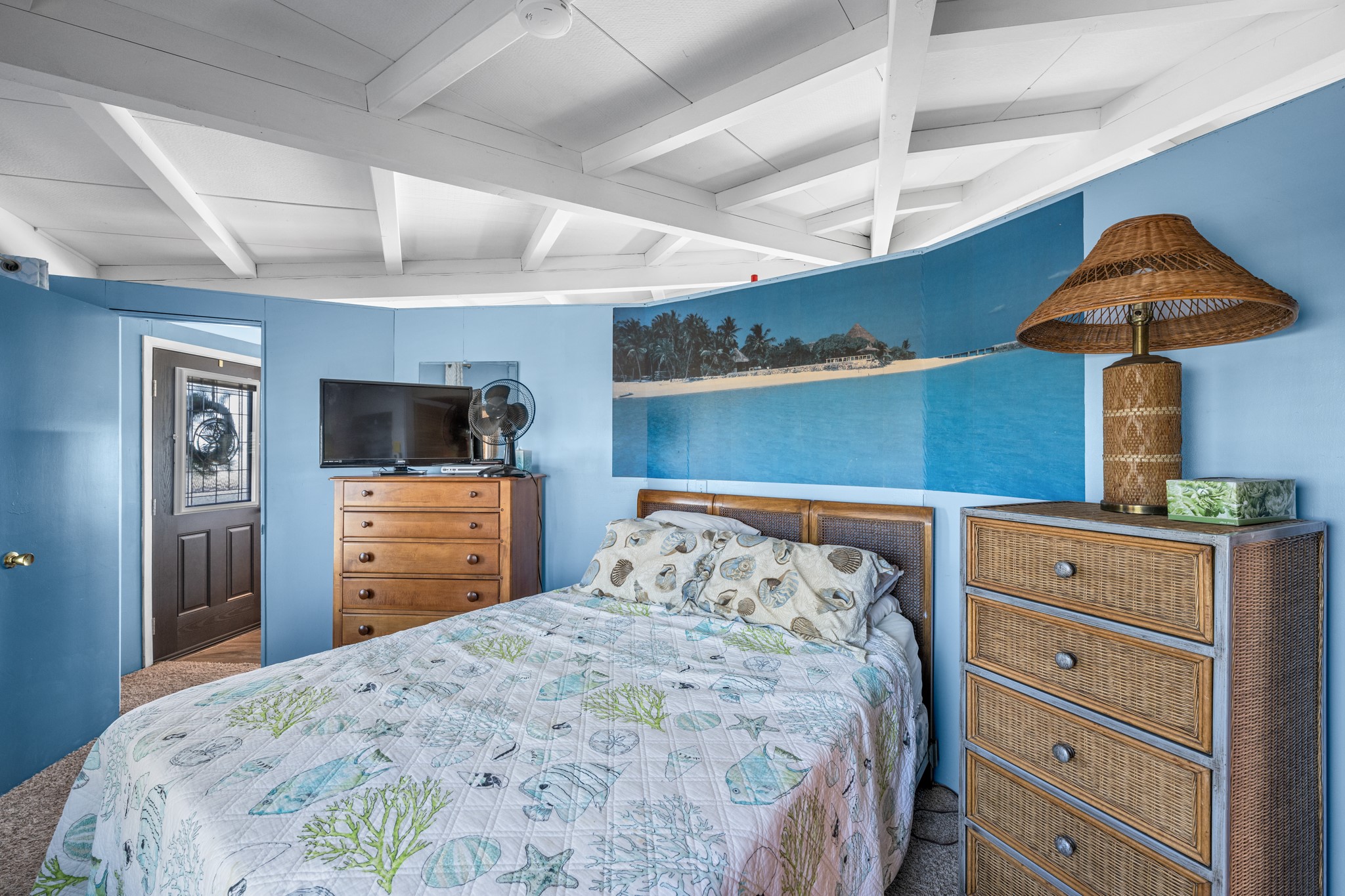 702 Seashell Drive Surfside Beach, TX 77541 - Photo 17 of 40 Peaceful retreat with tropical wall art, blue tones, and natural textures creating a relaxed beach cottage ambiance.