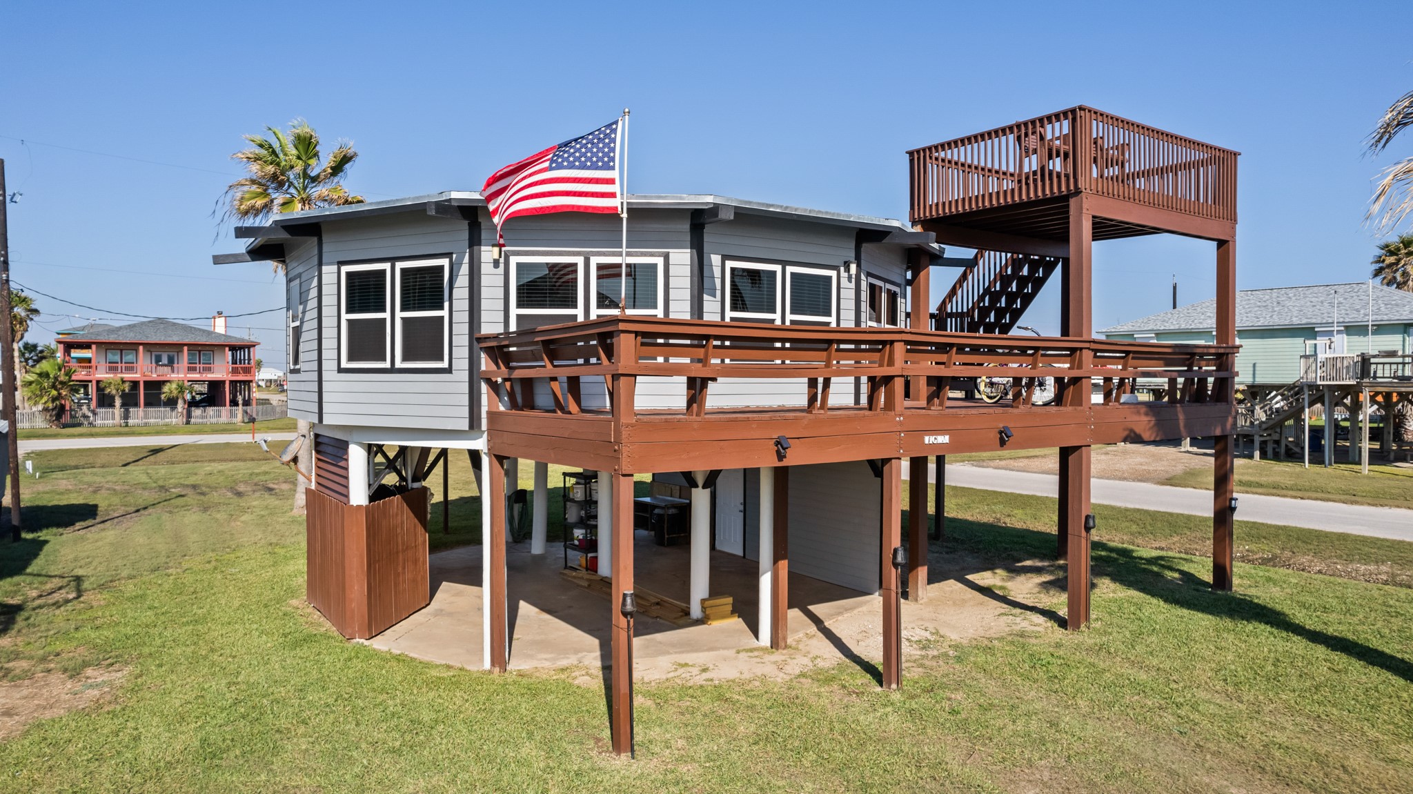702 Seashell Drive Surfside Beach, TX 77541 - Photo 2 of 40 Stylish coastal home elevated on pilings with expansive wraparound decking and a spacious upper observation deck, perfect for soaking in the sea breeze and sunshine.