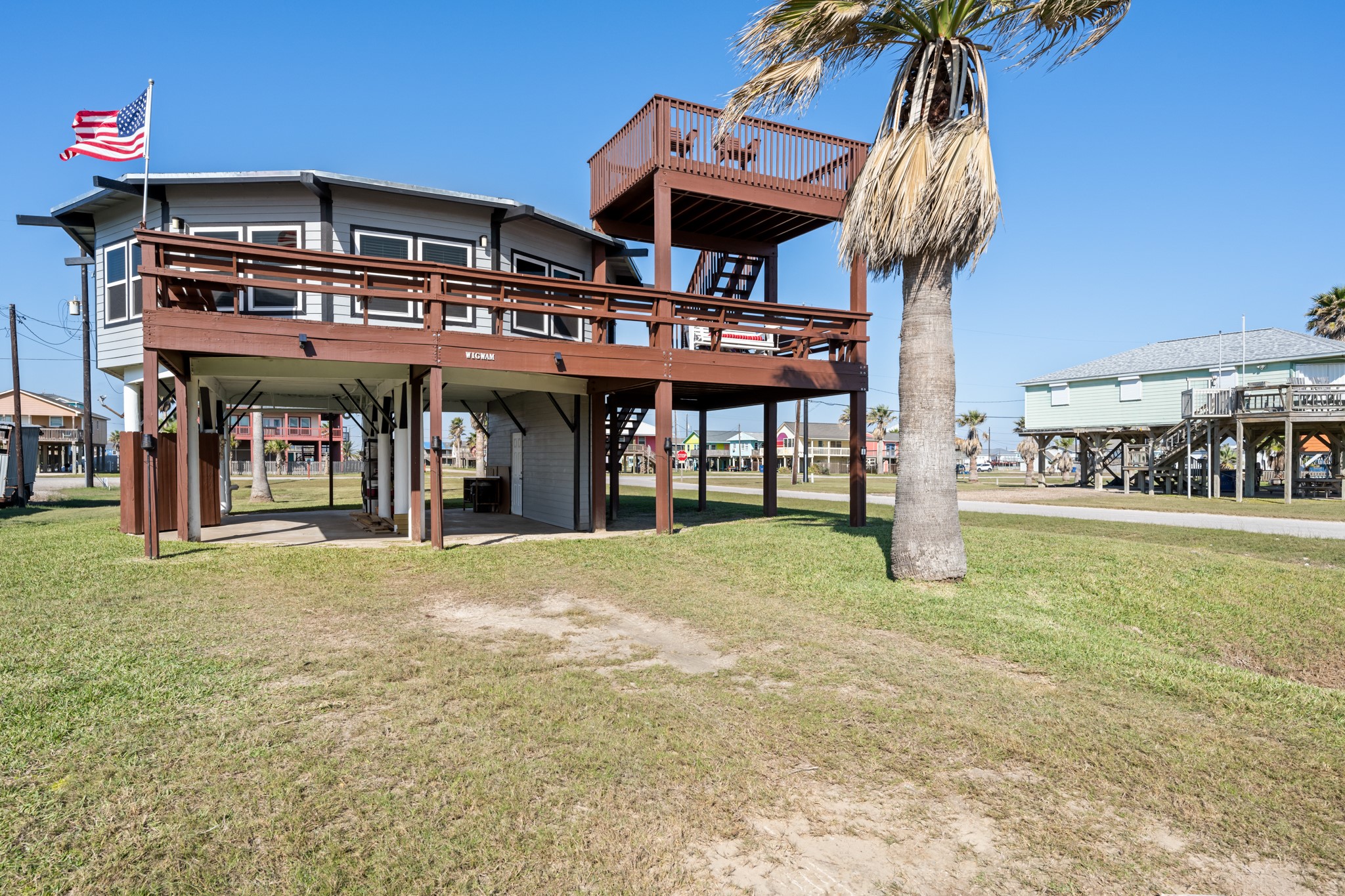 702 Seashell Drive Surfside Beach, TX 77541 - Photo 32 of 40 Crisp gray siding and rich wood-toned decks give this beach house a clean, modern look. The elevated design adds storage and shaded lounging space beneath, ideal for outdoor living or entertaining.