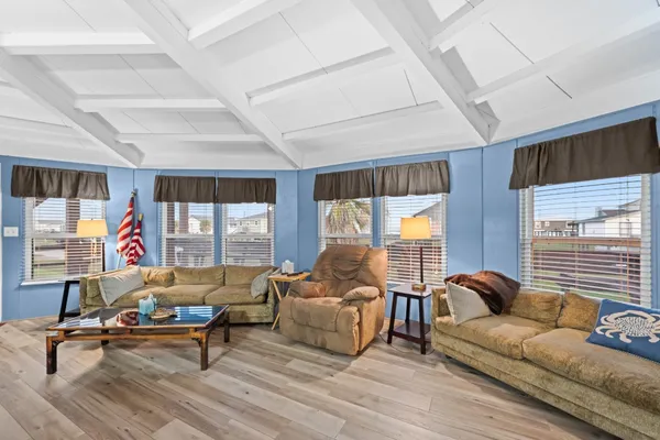a living room with furniture a flat screen tv and a large window