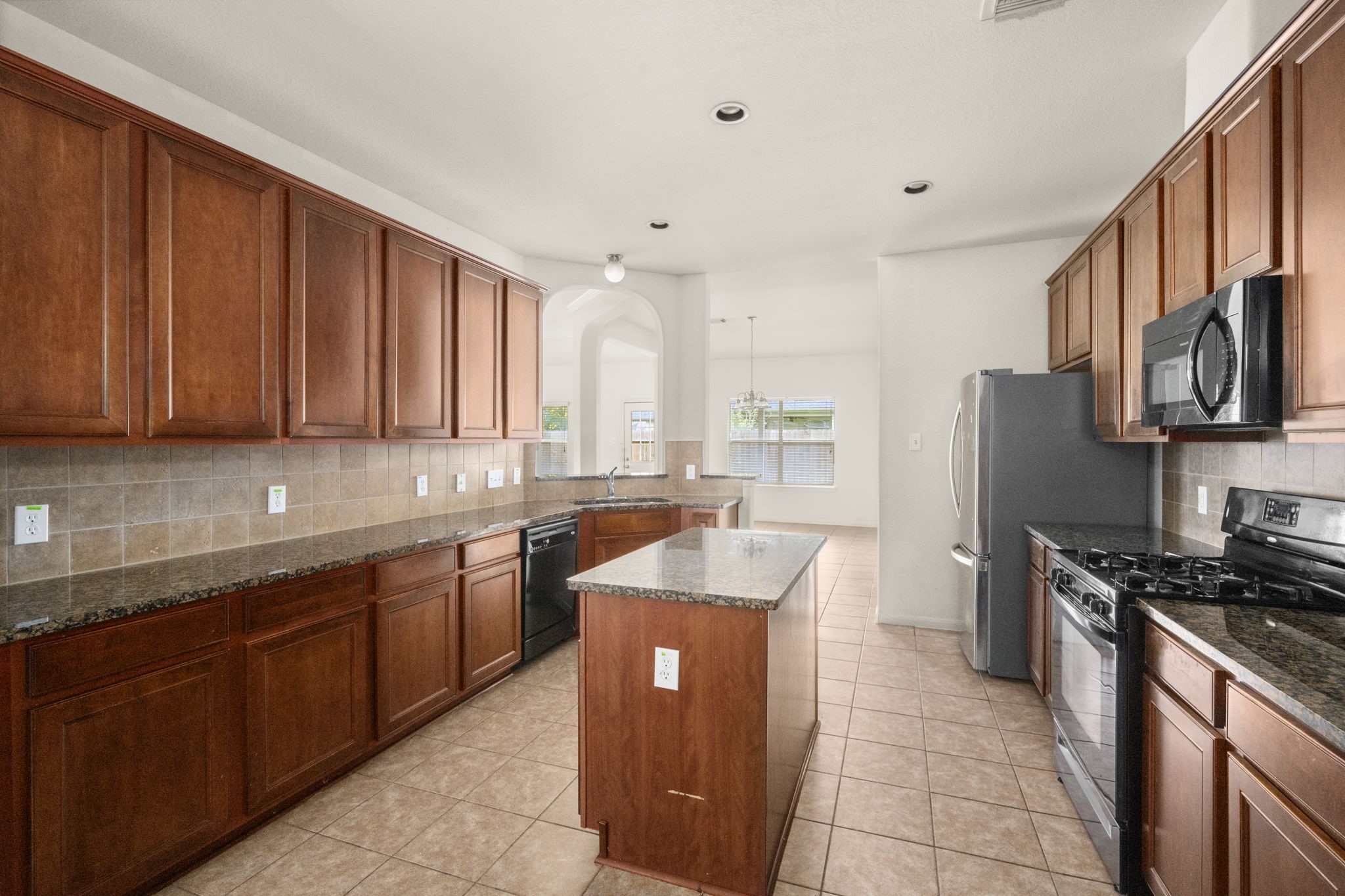 7803 Blue Lake Drive Rosenberg, TX 77469 - Photo 18 of 31 a large kitchen with stainless steel appliances granite countertop a sink stove and refrigerator