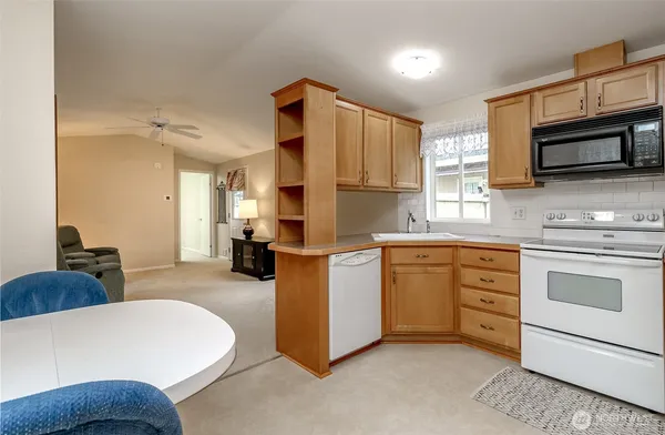 a kitchen with stainless steel appliances a stove a sink cabinets and a refrigerator