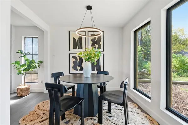 a dining room with furniture potted plants and wooden floor