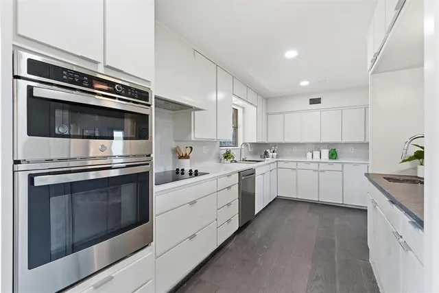 a kitchen with granite countertop cabinets stainless steel appliances and sink