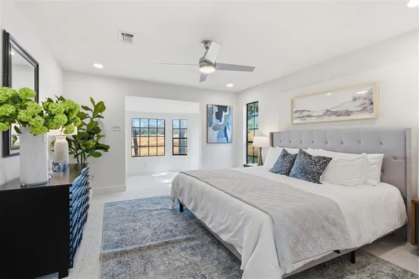 a bedroom with a large bed and a potted plant