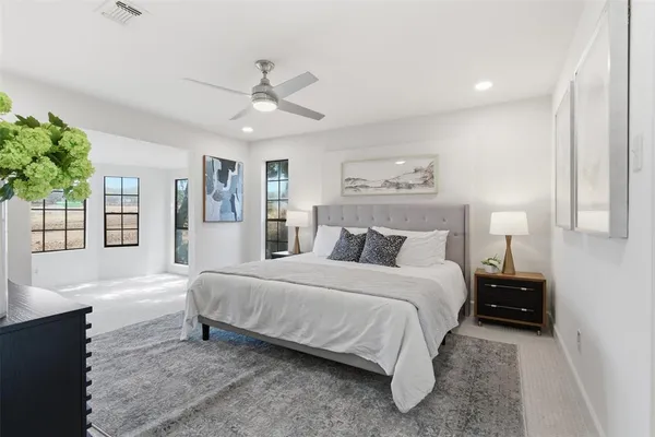 a bedroom with a large bed and a chandelier