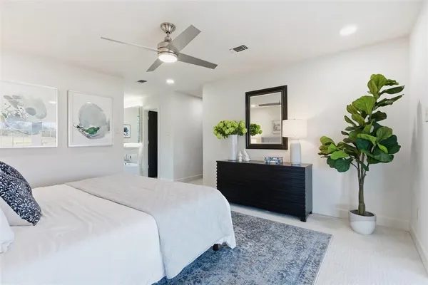 a bedroom with a bed potted plant and a dresser
