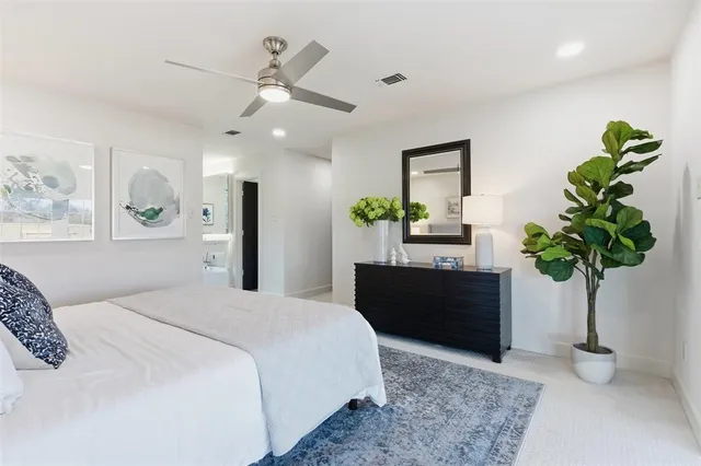 a bedroom with a bed potted plant and a dresser