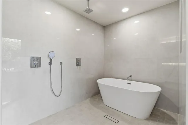 a bathroom with a white bath tub and a shower