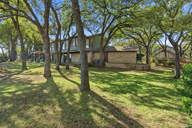 a view of a house with backyard and a tree
