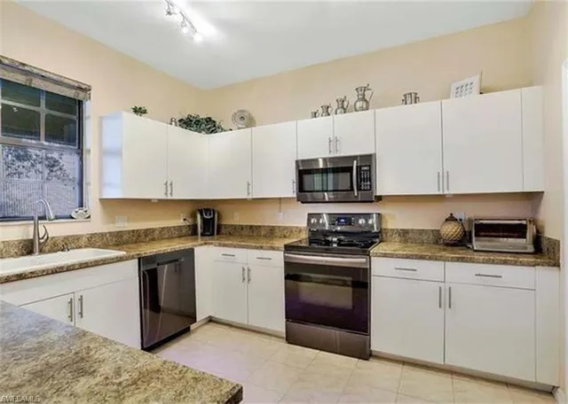 a kitchen with stainless steel appliances granite countertop a sink stove and microwave