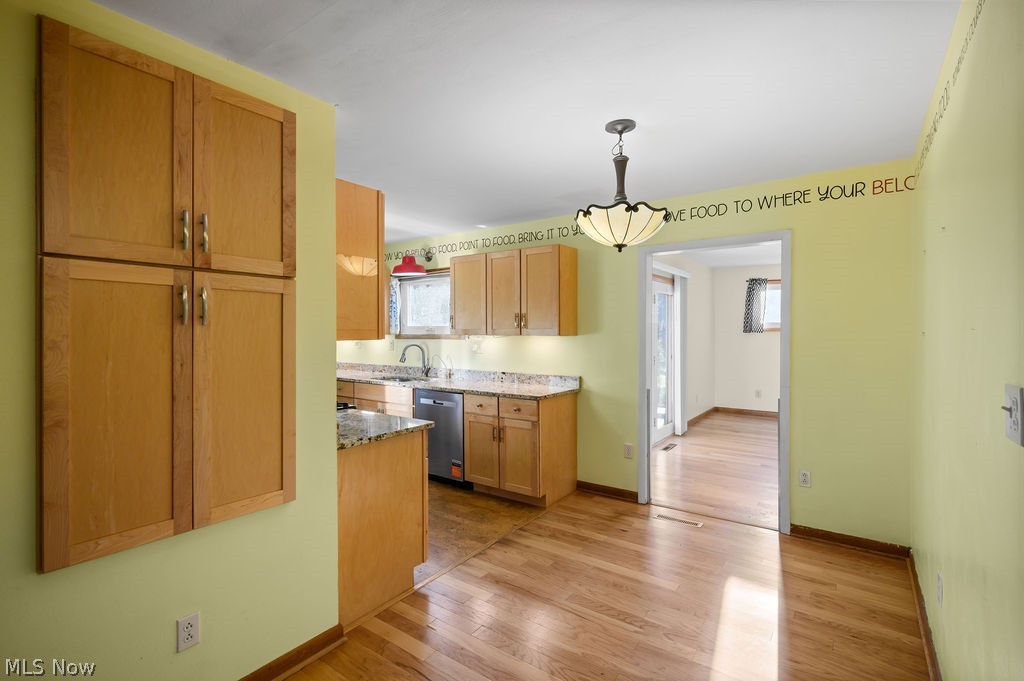 11363 Dupont Road Washington, WV 26181 - Photo 6 of 42 Kitchen featuring wood-finish cabinetry, light-toned countertops, stainless steel dishwasher, and wood-finish flooring
