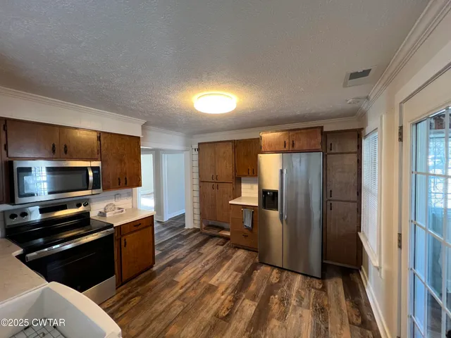a kitchen with stainless steel appliances granite countertop a refrigerator and a stove top oven