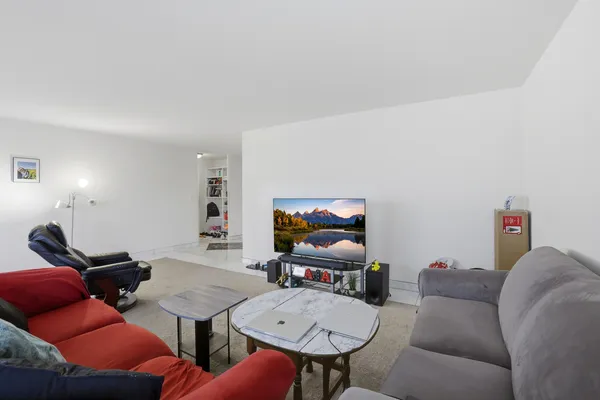 a living room with furniture a flat screen tv and rug