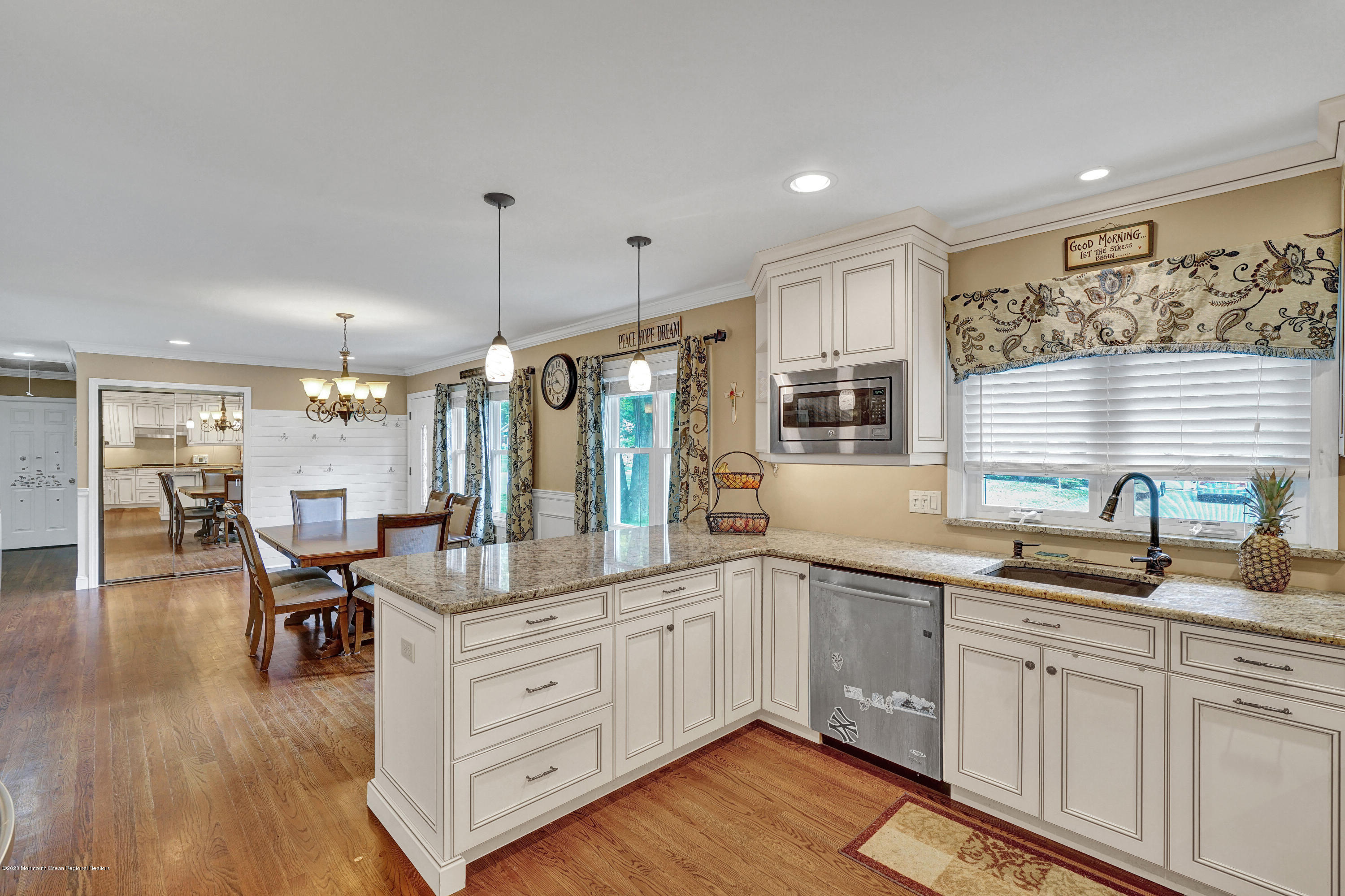 712 Midstreams Road Brick, NJ 08724 - Photo 14 of 33 a kitchen with granite countertop a stove a sink and white cabinets with wooden floor