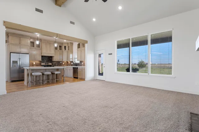 an empty room with chandelier and windows