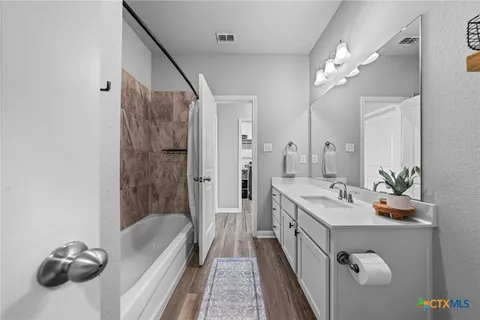 a spacious bathroom with a tub sink and mirror