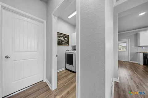a view of a hallway with wooden floor and closet area