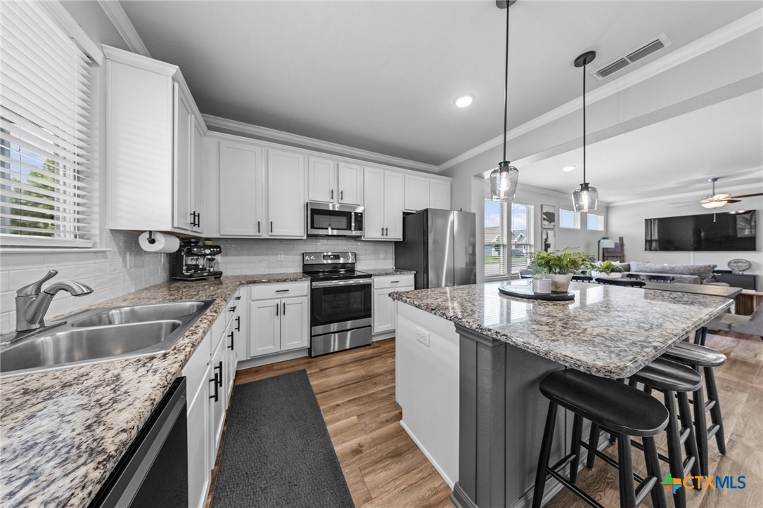 7513 Hudson Grove Drive Temple, TX 76502 - Photo 21 of 38 a kitchen with kitchen island granite countertop a sink a counter top space appliances and cabinets