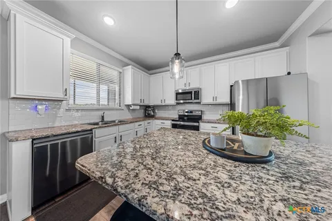 a kitchen with a stove a sink and cabinets