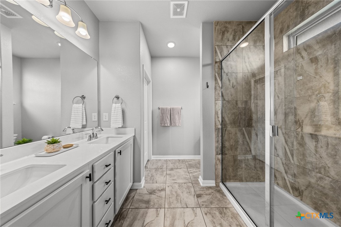7513 Hudson Grove Drive Temple, TX 76502 - Photo 29 of 38 a bathroom with a double vanity sink mirror and shower