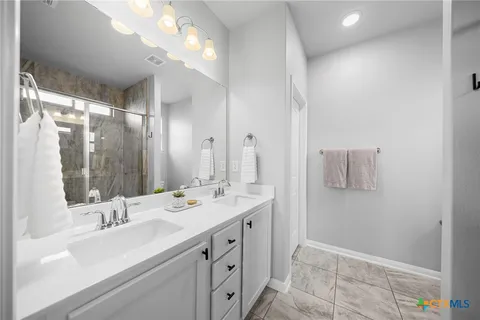 a bathroom with a sink double vanity and a mirror