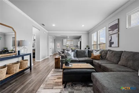 a living room with furniture wooden floor and a window