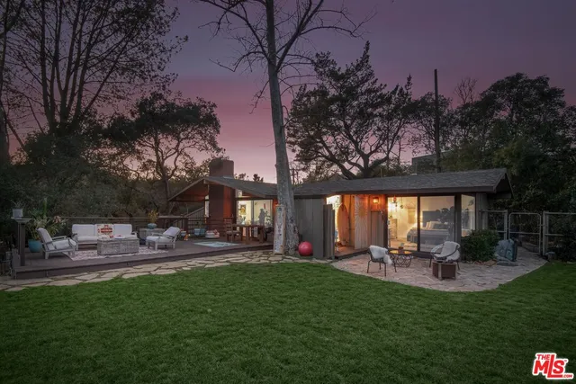 a view of a backyard with table and chairs with wooden fence