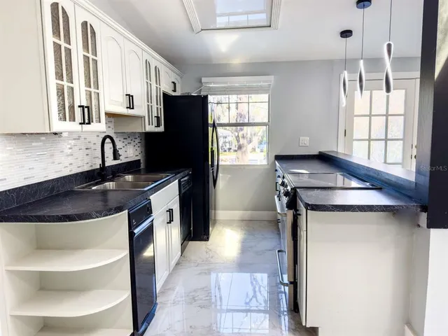 a kitchen with stainless steel appliances granite countertop a sink stove and refrigerator