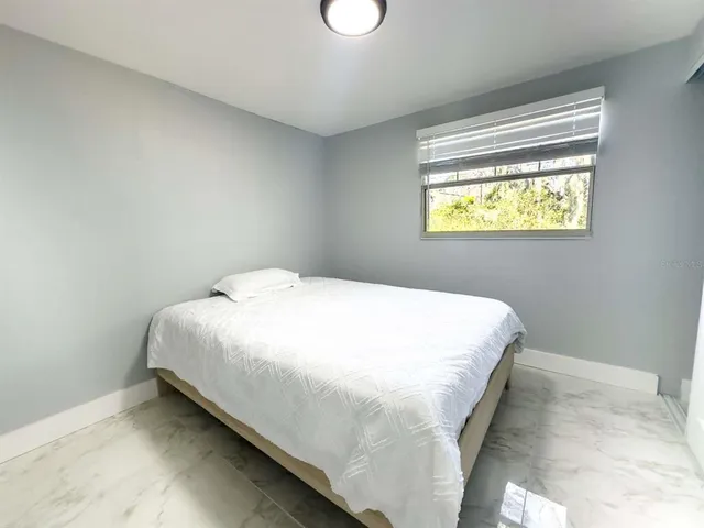 a bed sitting in a bedroom next to a window